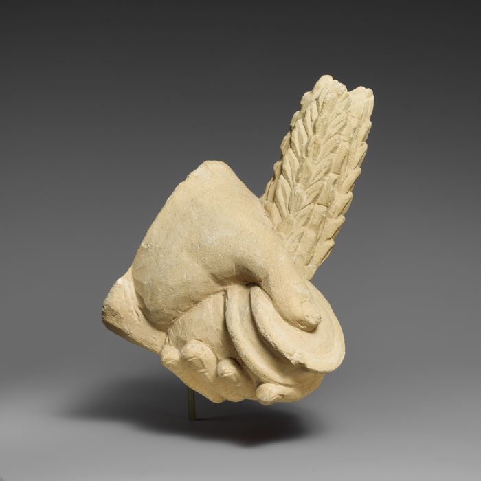 Limestone hand holding a pyxis and a branch of leaves