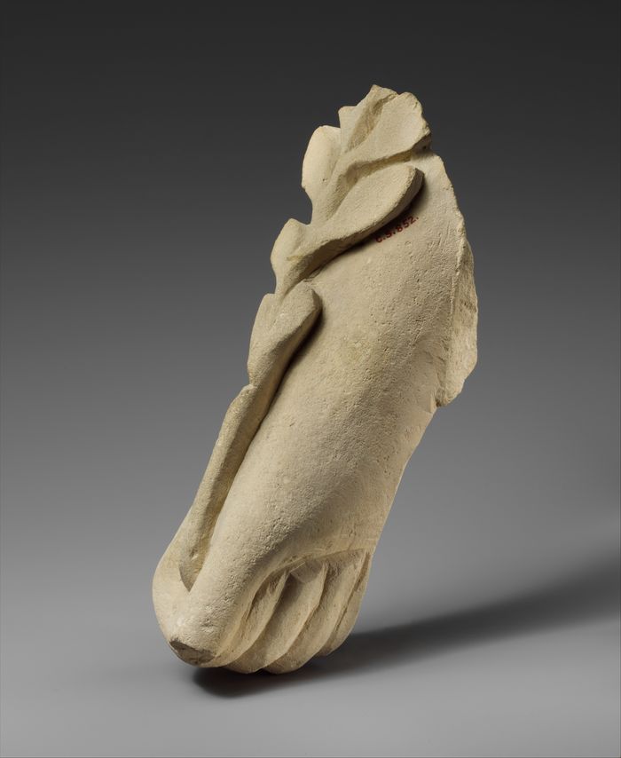 Limestone hand holding a branch of leaves