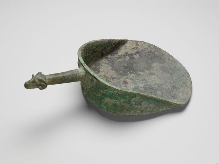 Bronze shovel with a handle terminating in a ram's head